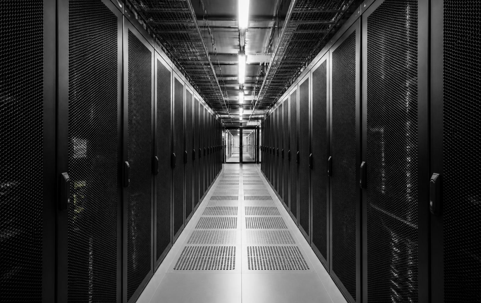 Monochrome view of a data centre corridor lined with server racks